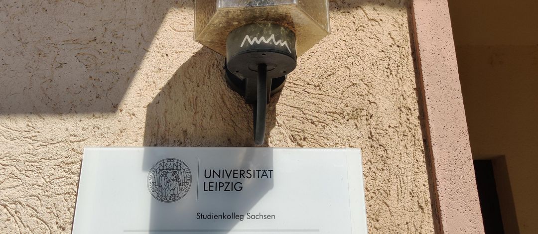 Blick auf das Türschild und eine Lampe am Eingang des Studienkollegs Sachsen in der Lumumbastraße, ein Foto von Dorothée Mießner-Dornburg